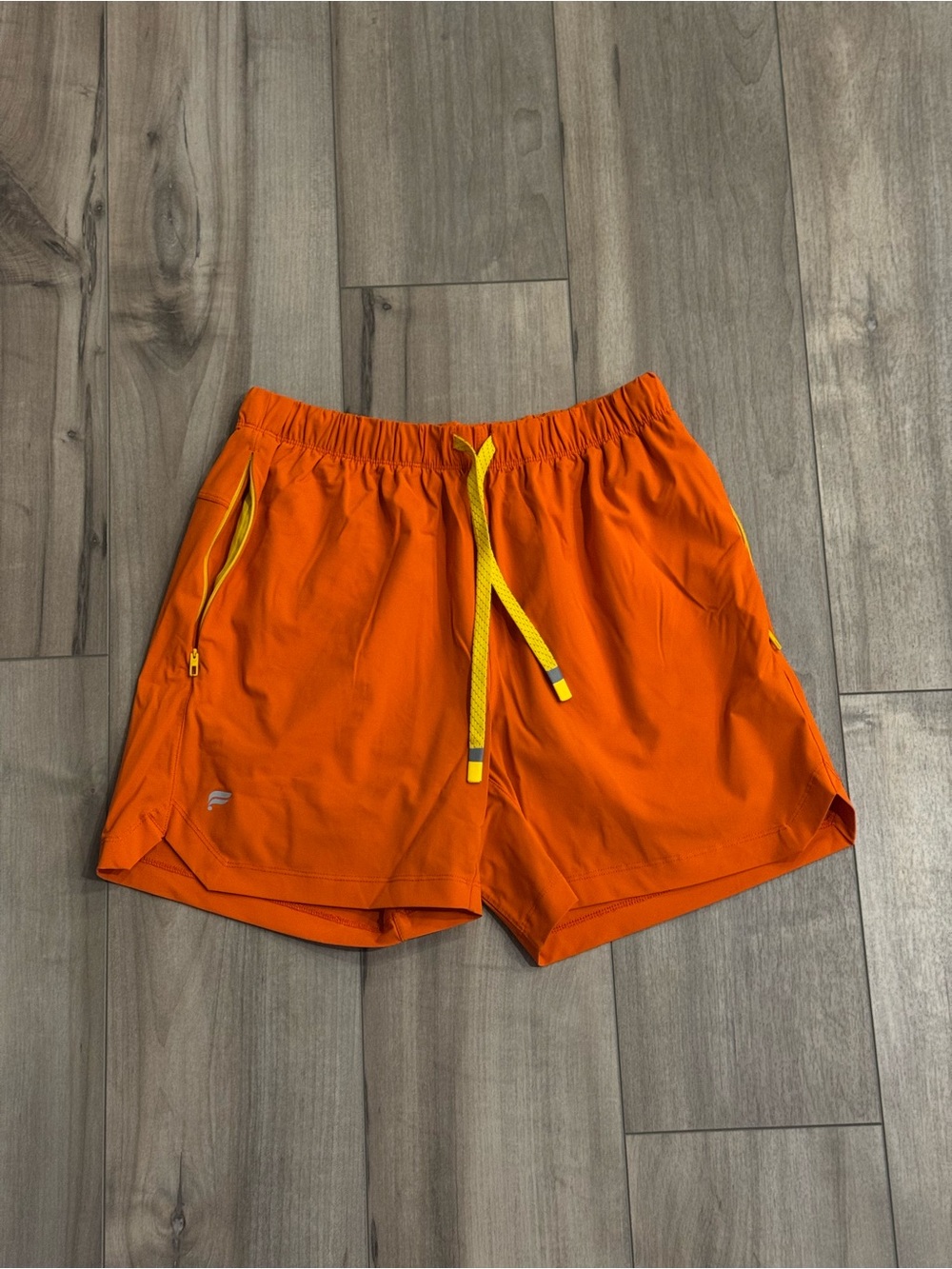 Fabletics’ Orange Athletic Shorts with Yellow Drawstring